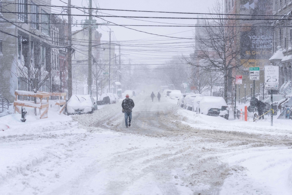 A person trudges through heavy snow on February 23, 2026 in the Brooklyn borough of New York City. Jeremy Weine/Getty Images/AFP