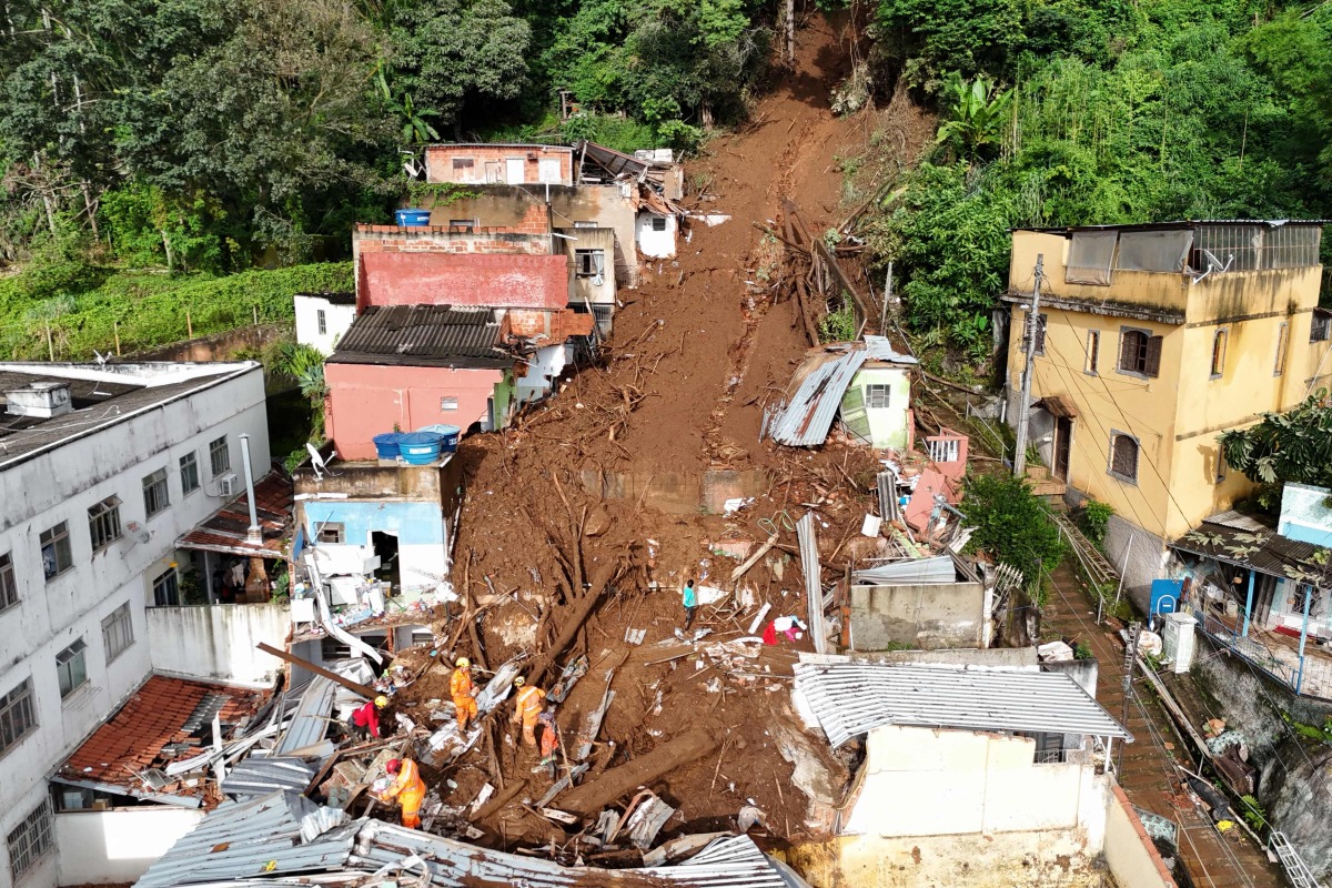 In this aerial view rescuers search for victims amid the rubble and mud of a house after a landslide triggered by heavy rains in the Paineiras neighborhood in Juiz de Fora, Minas Gerais State, Brazil, on February 25, 2026. Photo by Pablo PORCIUNCULA / AFP