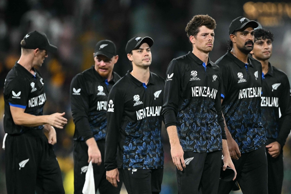 New Zealand's captain Mitchell Santner (3R) walks off the ground with his teammates following their win at the R Premadasa Stadium in Colombo on February 25, 2026. (Photo by Dibyangshu Sarkar / AFP)