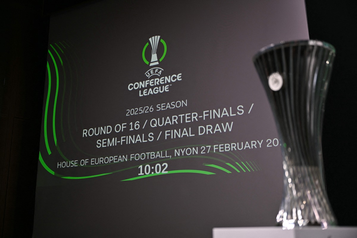 This photograph shows the UEFA Conference League Cup displayed next to a screen announcing the 2025-2026 UEFA Conference League round of 16, quarter-final and semi-final draw at the House of European Football in Nyon, western Switzerland on February 27, 2026. (Photo by Harold CUNNINGHAM / AFP)