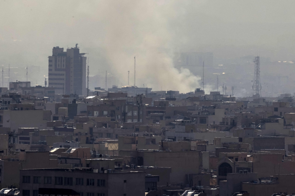 A plume of smoke rises following a reported explosion in Tehran on February 28, 2026. (Photo by Atta Kenare / AFP)