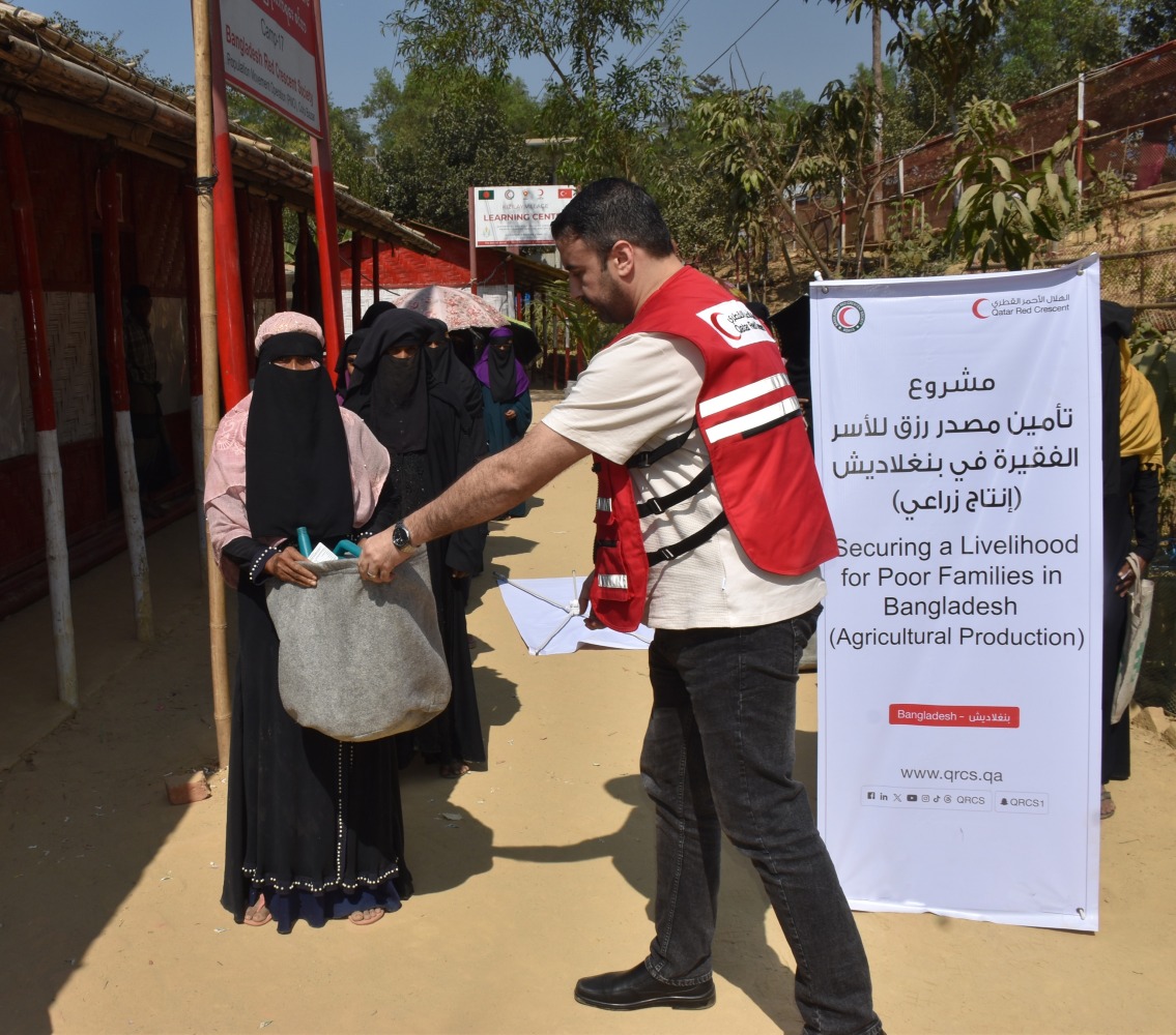 A Qatar Red Crescent Society representative distributing agricultural kits to female-headed households in Bangladesh.
