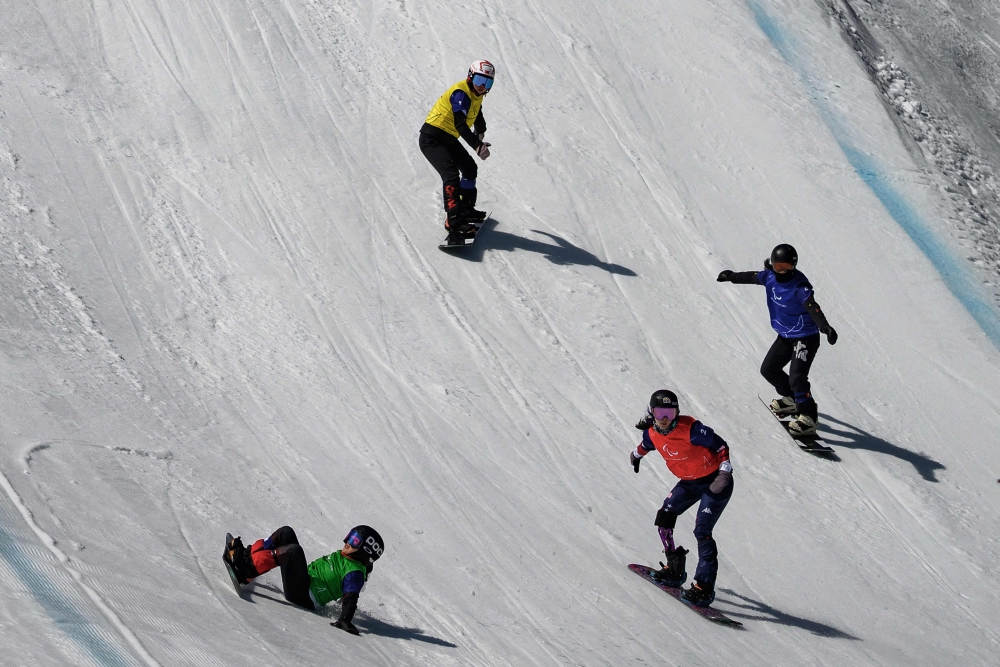 Athletes compete in the women's snowboard cross event during the Milano Cortina 2026 Paralympic Winter Games in Cortina d'Ampezzo on March 8, 2026. (Photo by JEFF PACHOUD / AFP)