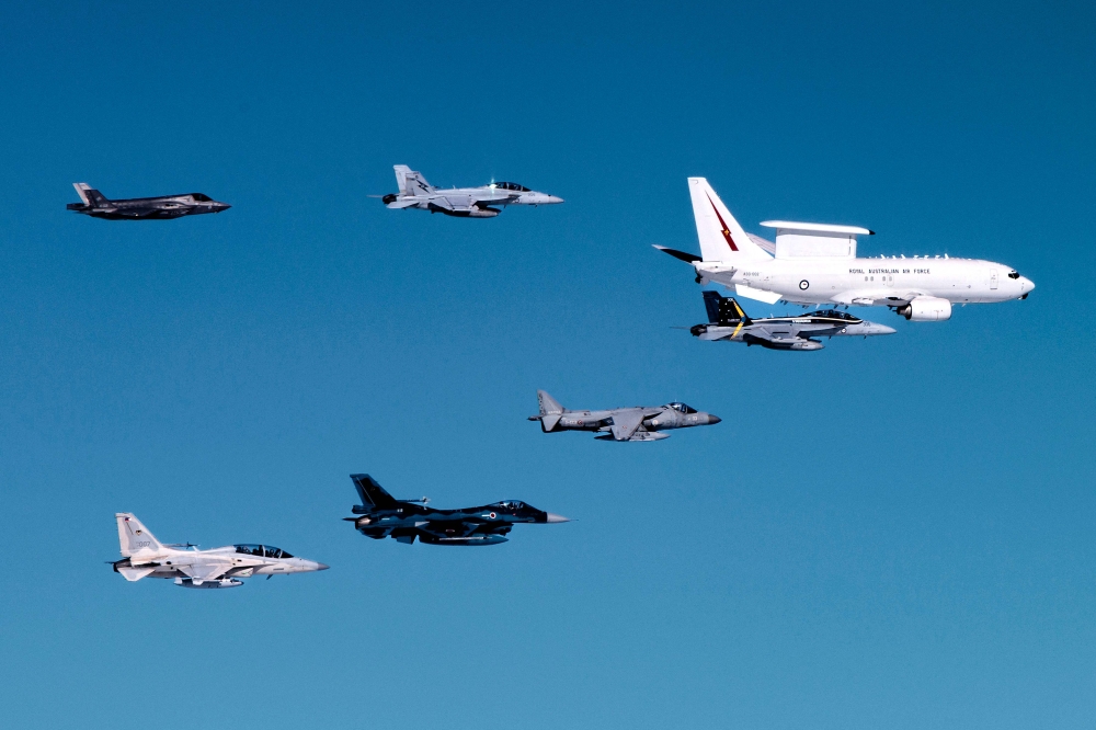 This handout image taken on July 23, 2024 and released by the Australian Defence Force shows a Royal Australian Air Force (RAAF) E-7A Wedgetail airborne early warning and control aircraft (top R) in formation flight with an RAAF EA-18G Growler electronic warfare aircraft (bottom R), RAAF F/A-18F Super Hornet (top C), a Spanish Navy AV-8B Harrier II (bottom C), an F-35 Lightning II (top L), a Japan Air Self-Defense Force Mitsubishi F-2 (bottom 2nd L), and a Philippine Air Force FA-50 Golden Eagle (bottom L) over northern Australia during Exercise Pitch Black 2024. (Photo by Handout / Australia Defence Force / AFP) 