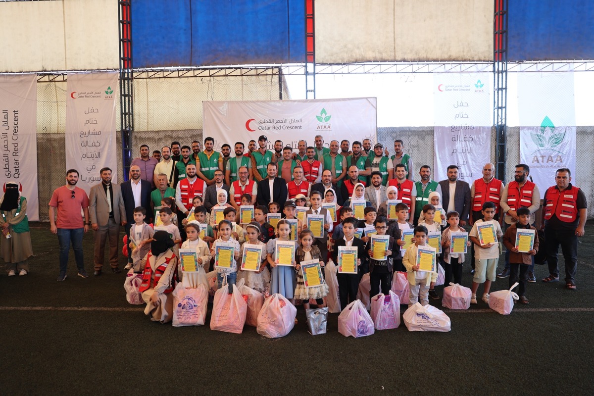 QRCS representatives with the orphans in Syria. (File photo)