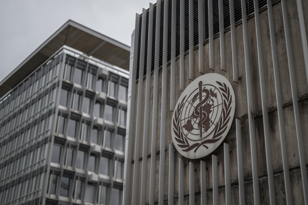 This photograph shows a logo of the World Health Organisation (WHO) displayed on the facade of organisation's headquarters in Geneva on April 23, 2025. Photo by Fabrice COFFRINI / AFP