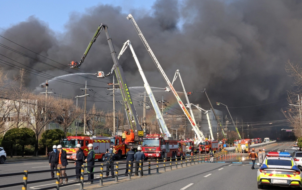 Firefighters spray water to extinguish a fire at a car parts plant in Daejeon on March 20, 2026. (Photo by Yonhap / AFP) 