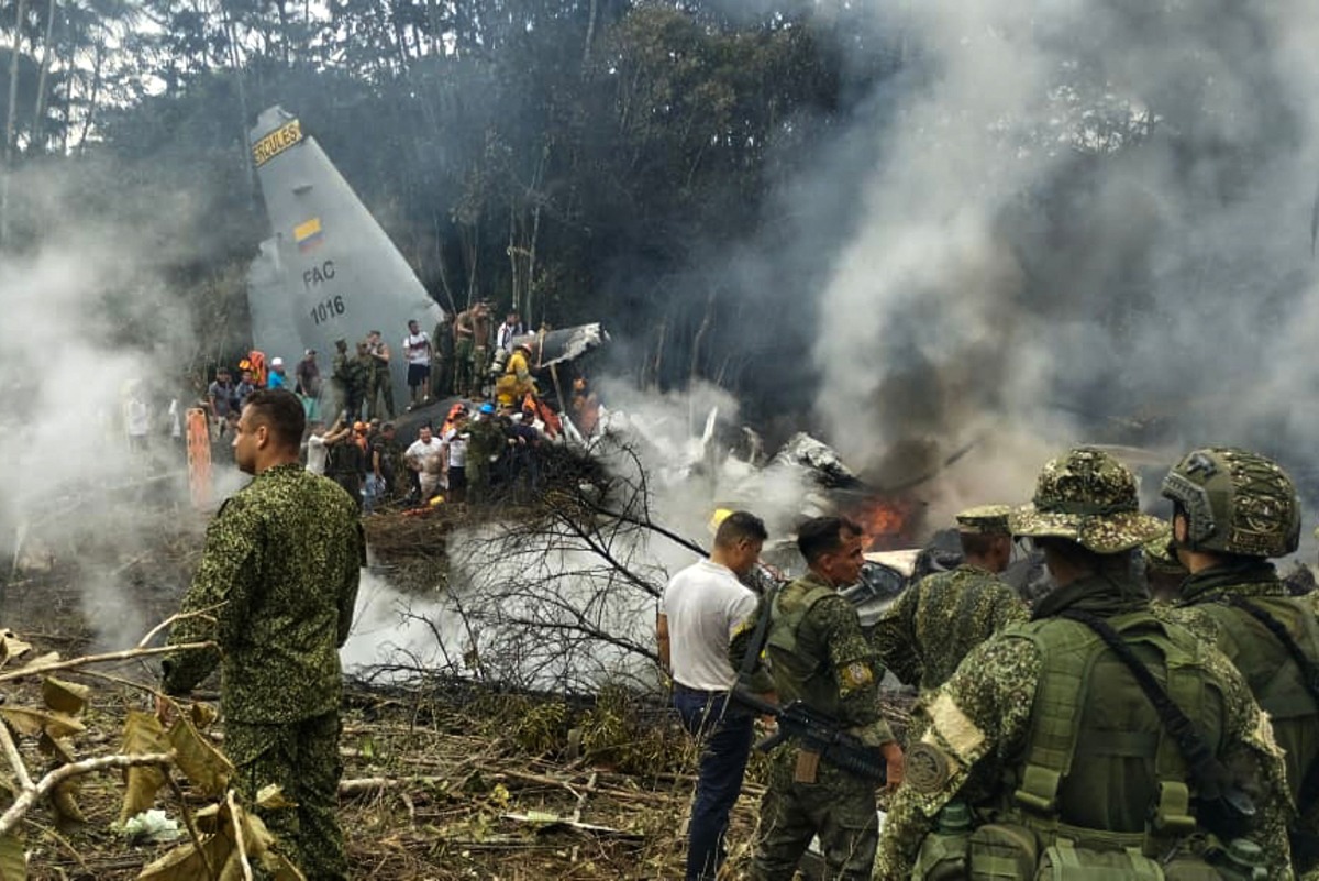 This screen grab shows soldiers and rescuers near an Air Force Hercules emitting thick smoke after the aircraft crashed during takeoff in Puerto Leguizamo, Colombia, near the southern border with Ecuador, on March 23, 2026. (Photo by daniel ortiz / AFP)
