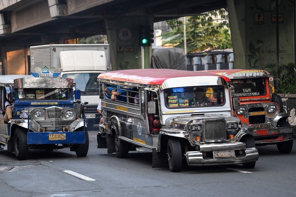 Jeepneys ply their route along a street in Manila on March 23, 2026.Photo by Ted ALJIBE / AFP