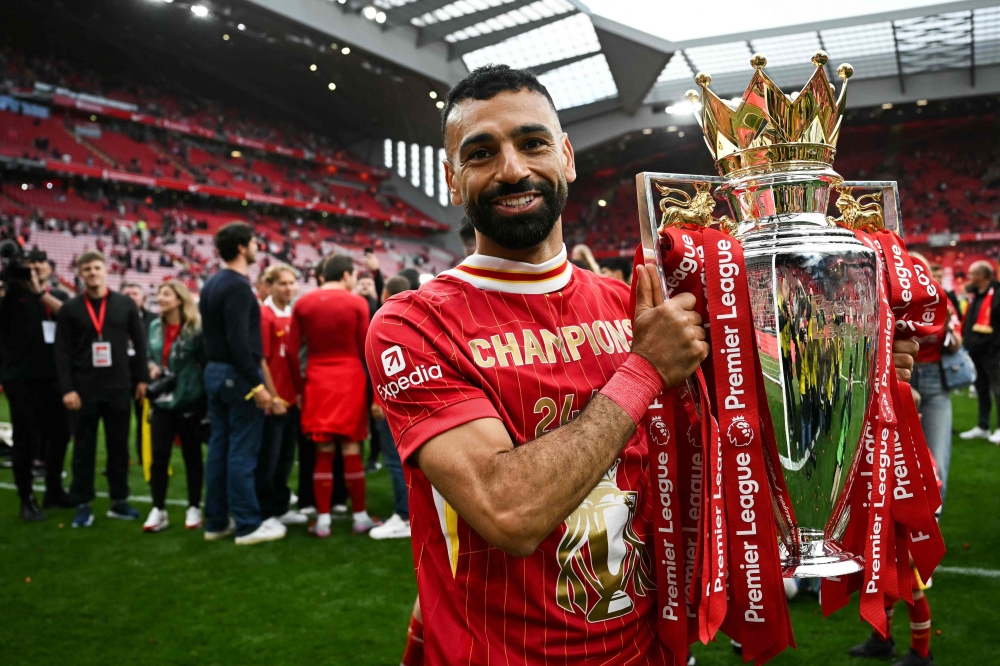 (Files) Liverpool's Egyptian striker #11 Mohamed Salah celebrates with the Premier League trophy on May 25, 2025. (Photo by Paul Ellis / AFP)