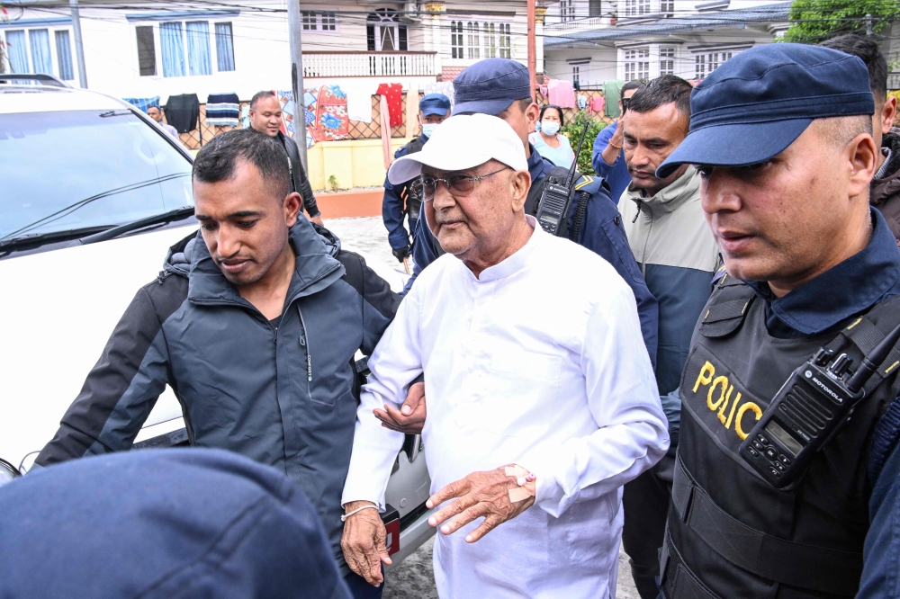 Nepal's former prime minister KP Sharma Oli (C) is escorted by police as he is brought to the hospital following his arrest in Kathmandu on March 28, 2026. (Photo by Prakash Mathema / AFP)