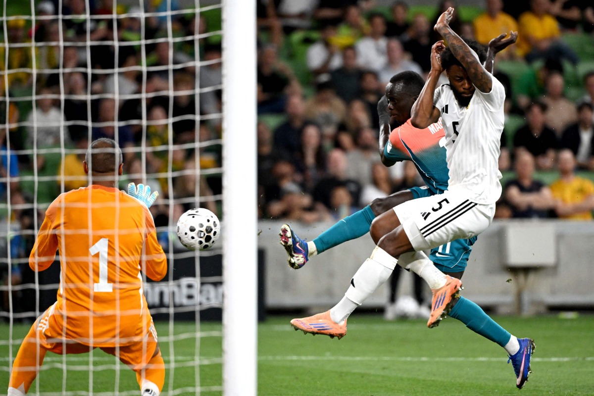 Australia's Awer Mabil (centre) shoots to score against Curacao.