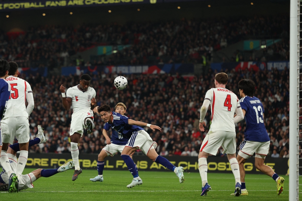 England's defender Marc Guehi (L) heads towards goal during the friendly international football match between England and Japan at Wembley Stadium in London on March 31, 2026. (Photo by Adrian Dennis / AFP) 