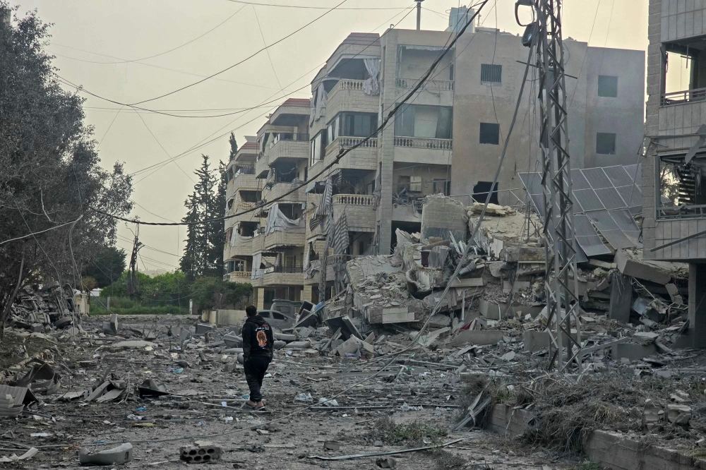 A man walks through the debris of destroyed buildings at the site of an Israeli airstrike in the Al Hosh area near the coastal Lebanese city of Tyre on April 4, 2026. (Photo by Kawnat Haju / AFP)