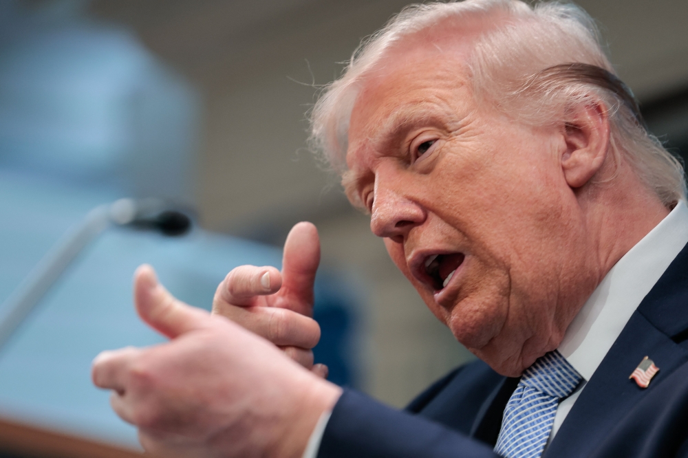 US President Donald Trump mimics firing a gun as he speaks about the conflict in Iran in the James S. Brady Press Briefing Room of the White House on April 6, 2026, in Washington, DC. (Photo by Kent Nishimura / AFP)