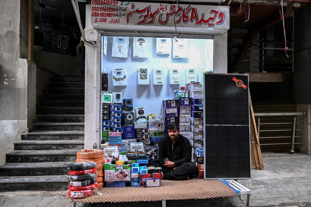 This photograph taken on April 4, 2026 shows a shopkeeper selling solar panels awaiting customers at an electrical appliance store in Rawalpindi. (Photo by Farooq Naeem / AFP)