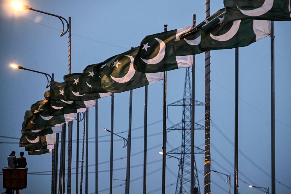 Capital Development Authority (CDA) workers set up Pakistan's national flags along a street in Islamabad on April 18, 2026. 

Photo by Farooq NAEEM / AFP