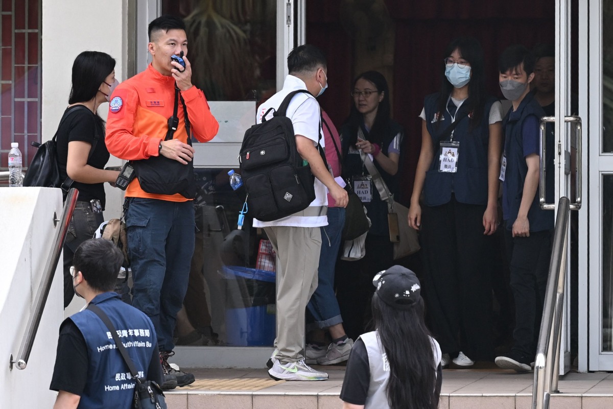 Residents of Wang Fuk Court residential estate arrive to return to their apartments in Hong Kong on April 20, 2026. Photo by Peter PARKS / AFP