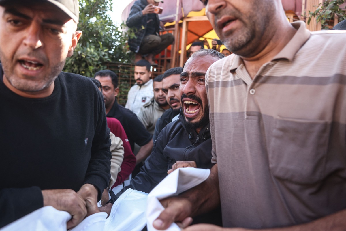 A Palestinian man reacts as he and others carry the body of a victim at the Nasser Hospital following an Israeli airstrike in the city of Khan Yunis, in the southern Gaza Strip on April 21, 2026. (Photo by Bashar Taleb / AFP)