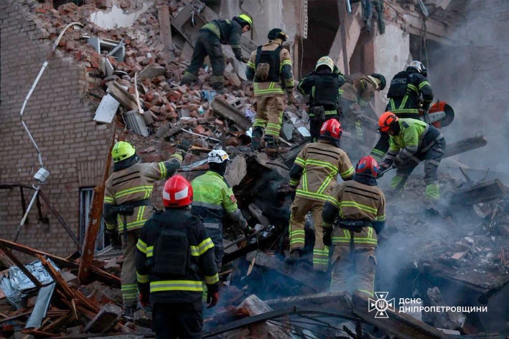 This handout photograph taken and released by the State Emergency Service of Ukraine on April 25, 2026 shows Ukrainian rescuers clearing debris in a residential building following a Russian attack in Dnipro, amid the Russian invasion of Ukraine. (Photo by Handout / State Emergency Service of Ukraine / AFP) 