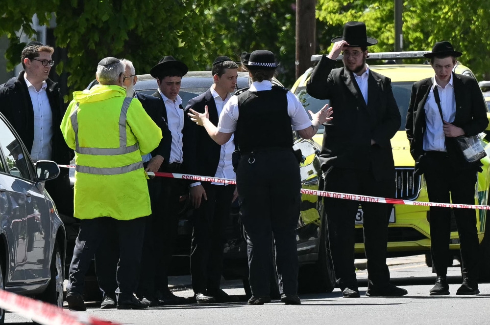 TOPSHOT-BRITAIN-CRIME-POLICE-RELIGION
Local residents look on from outside a cordoned off area in the Golders Green neighbourhood of north London on April 29, 2026, following the stabbing to two people nearby.
 (Photo by JUSTIN TALLIS / AFP)