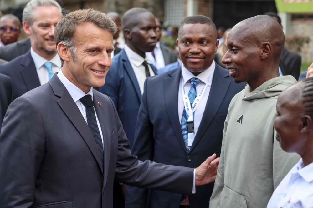 France's President Emmanuel Macron (L) speaks with Kenya's Sabastian Sawe (2nd R), the first man to run under two hours for a marathon in race conditions at a sport demonstration during the Africa Forward summit in Nairobi on May 11, 2026. (Photo by Ludovic Marin / AFP)
