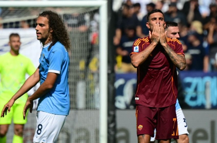 Roma's Italian midfielder #07 Lorenzo Pellegrini celebrates scoring his team's first goal next to Lazio's French midfielder #08 Matteo Guendouzi during the Italian Serie A football match between Lazio and Roma at the Olympic stadium in Rome, on September 21, 2025. (Photo by Tiziana FABI / AFP)