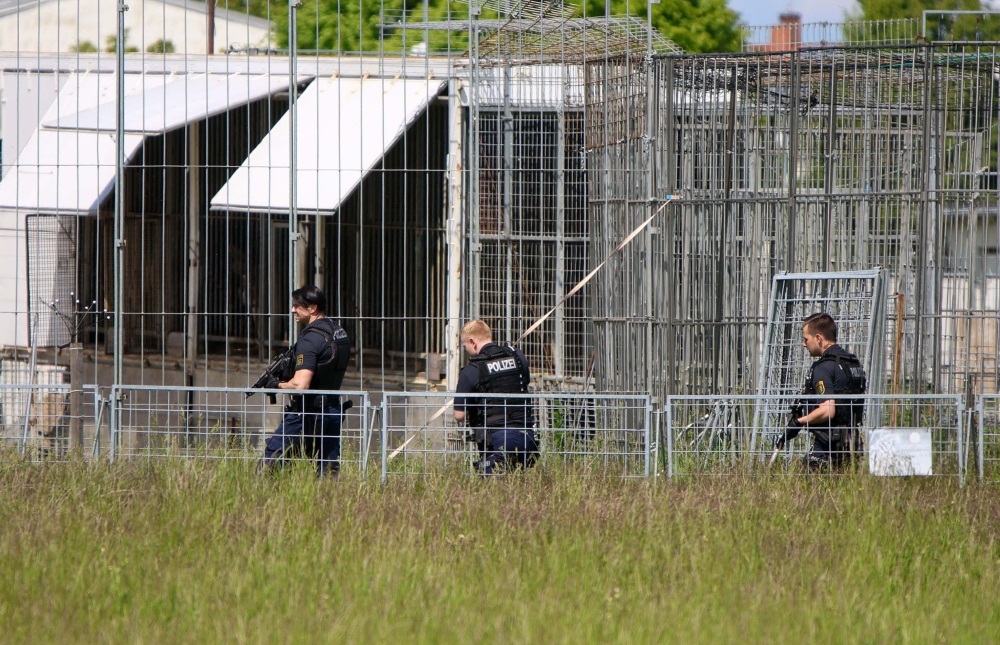 A picture showing heavily armed police officers in an industrial area at a cage facility in Schkeuditz near Leipzig, Saxony, eastern Germany, after an escaped tiger injured a man and was shot dead.  (Photo by Bjِrn Stach / dpa / AFP) / Germany OUT
 