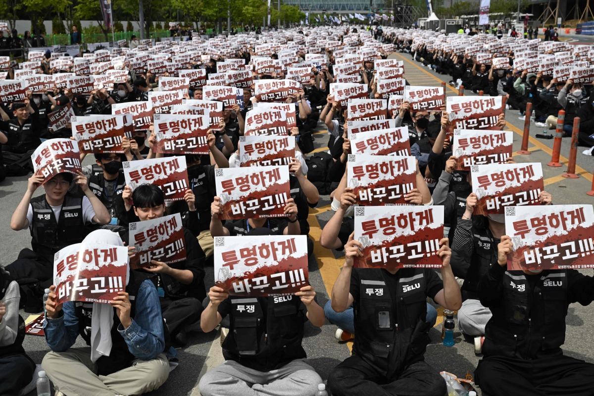 Members of the Samsung Electronics labour union hold signs reading 