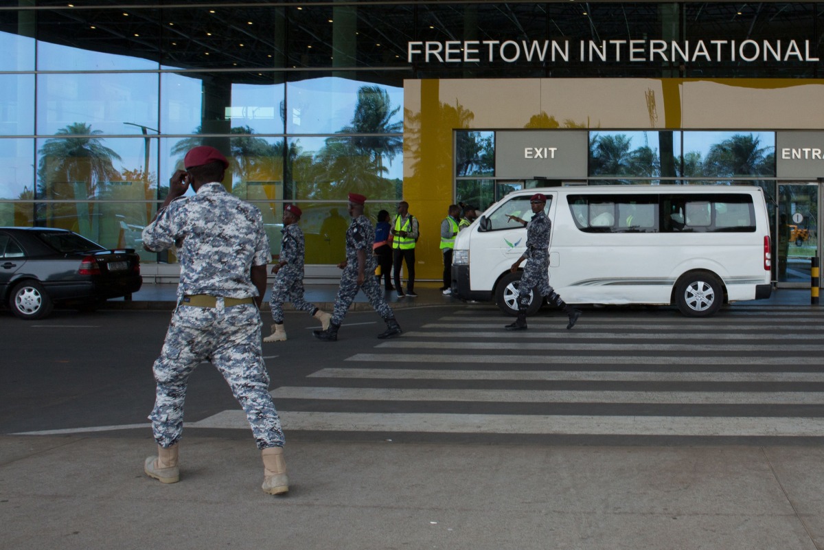 Security escort migrants in a National Public Health Agency (NPHA) after their arrival at Freetown International Airport, formerly known as Lungi International Airport, in Lungi on May 20, 2026. (Photo by AFP)