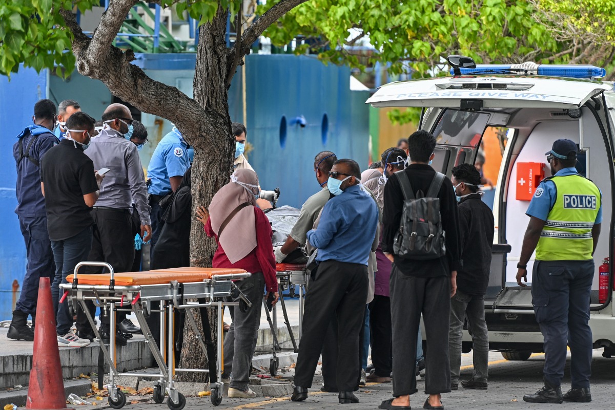 Red Crescent emergency responders and police personnel transfer the bodies of Italian tourists from a police speed boat to an ambulance in Male on May 19, 2026. Photo by MOHAMED AFRAH / AFP