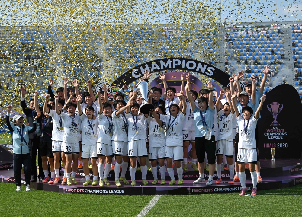 Naegohyang Women's FC players celebrate with the trophy during the victory ceremony after the AFC Women's Champions League final football match between North Korea's Naegohyang Women's FC and Japan's Tokyo Verdy Beleza in Suwon on May 23, 2026. (Photo by Jung Yeon-je / AFP)