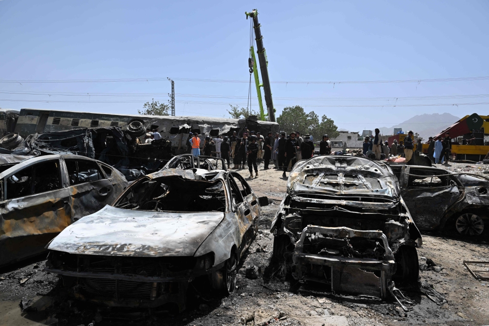 A crane lifts a carriage of a train at the site after an explosion that targeted a train in Quetta on May 24, 2026. (Photo by Banaras Khan / AFP)