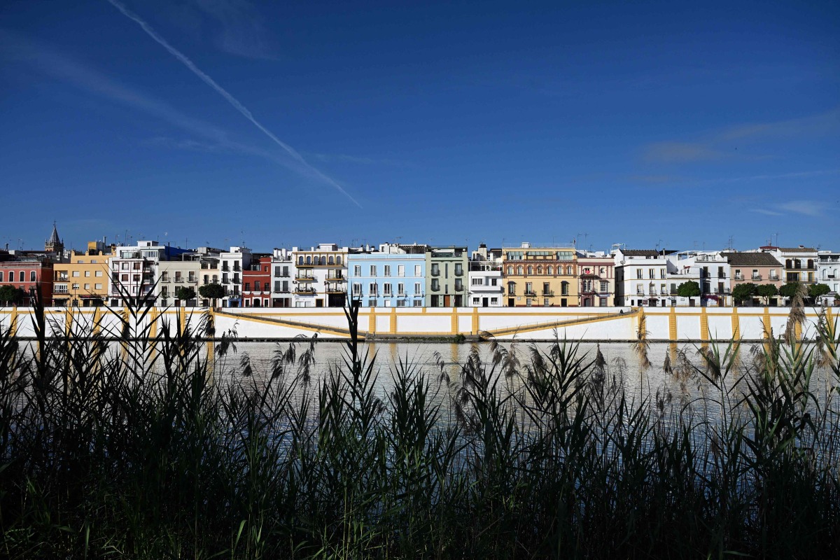 A picture taken on April 30, 2026 shows residential buildings alongside the Guadalquivir river on Betis street in Seville. Photo by CRISTINA QUICLER / AFP