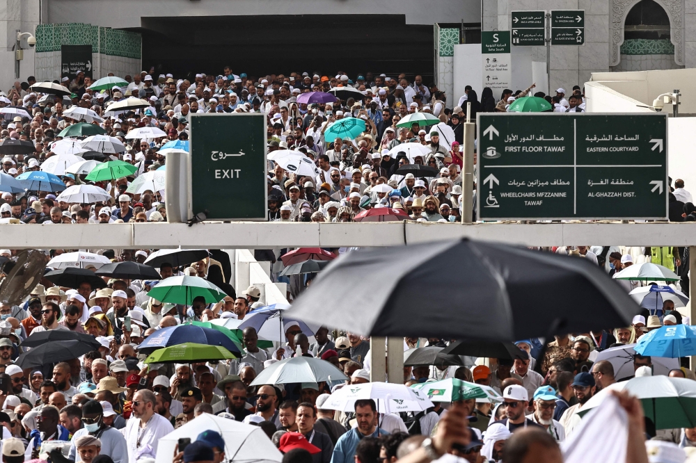 Muslim worshippers walk along the Grand Mosque complex under the water-mist fans installed in the holy city of Mecca on May 24, 2026, ahead of the annual Hajj pilgrimage. (Photo by Zain Jaafar / AFP)