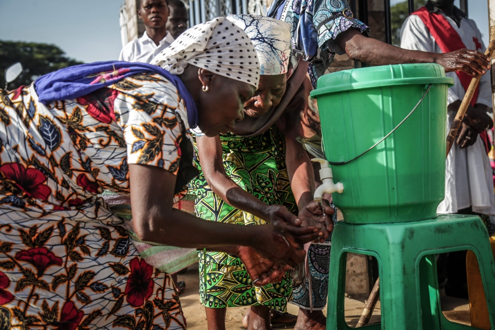 Parishioners wash their hands before entering the church following local authorities’ instructions to limit the spread of the Ebola outbreak in eastern Democratic Republic of the Congo in Bunia on May 24, 2026. (Photo by Seros Muyisa / AFP)