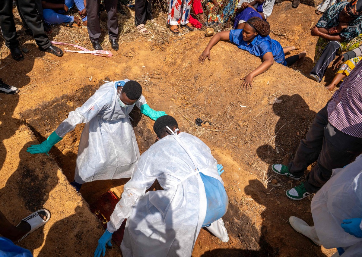 A woman (top R) reacts as a person suspected of having died from Ebola is buried in Bunia, in the eastern Democratic Republic of the Congo, on May 25, 2026. (Photo by Glody MURHABAZI / AFP)
