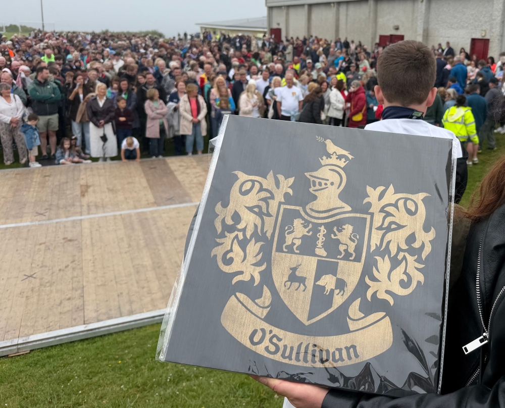 The O’Sullivan clan family crest is held by a participant in a bid to break a world record for the largest gathering of people with the same surname, in Castletownbere, Ireland (Photo by Peter Murphy/ AFP)