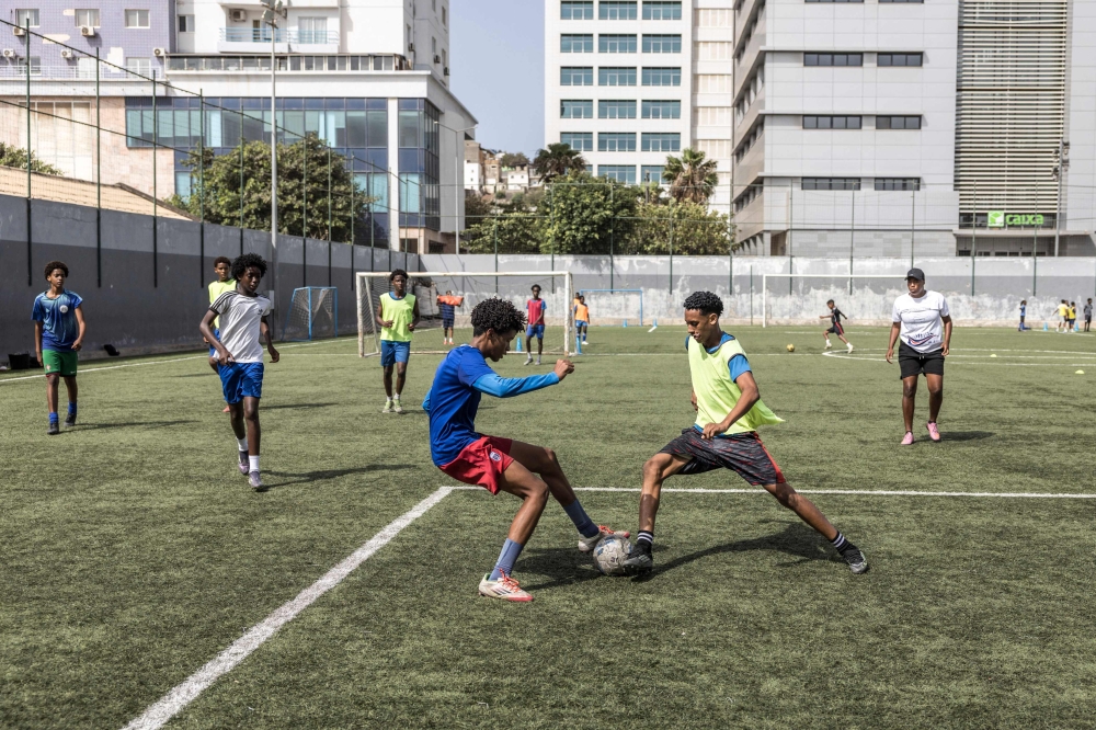 (Files) Football students play a game during practice at the Bola Pra Frente (Ball Forward) football academy in Praia, on May 18, 2026. (Photo by Patrick Meinhardt / AFP)