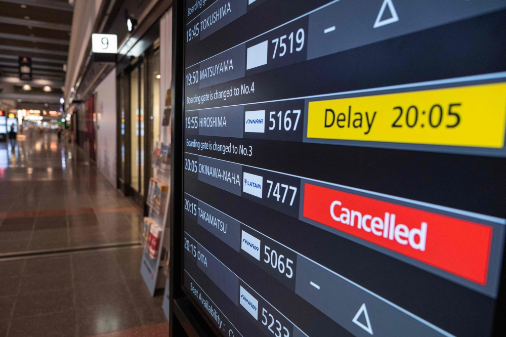 A departures board shows a cancelled flight to Okinawa after Severe Tropical Storm Jangmi shut down the airport at Haneda Airport in Tokyo on June 1, 2026. (Photo by Andrew Caballero-Reynolds / AFP)
