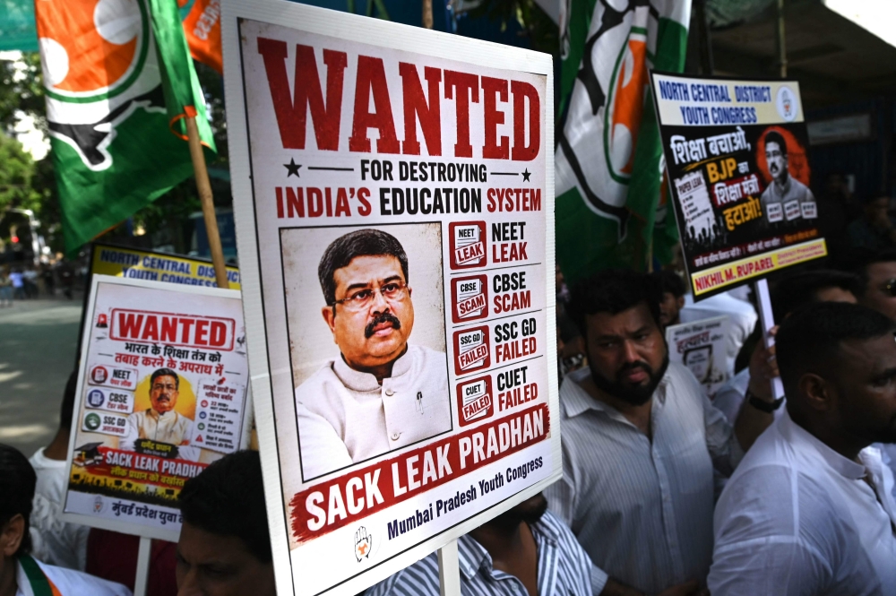 Indian Youth Congress party workers hold placards of India's Education Minister Dharmendra Pradhan during a protest against National Testing Agency (NTA) in Mumbai on June 2, 2026. (Photo by Indranil Mukherjee / AFP)