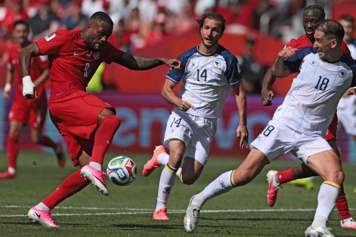 Canada's forward #09 Cyle Larin (L) scores the equalizer during the 2026 World Cup Group B football match between Canada and Bosnia and Herzegovina at the Toronto Stadium in Toronto on June 12, 2026. (Photo by Cole Burston / AFP)