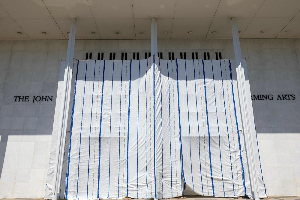 Tarps are hung on scaffolding outside The Kennedy Center on June 13, 2026 in Washington, DC. Friday late night workers removed the President Donald Trump's name from the Kennedy Center. (Photo by Tasos Katopodis/AFP)