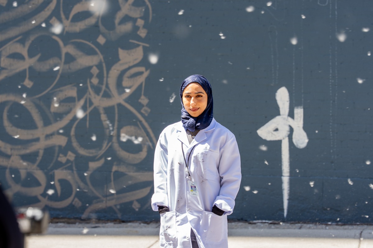 Fatima Alsharshani in front of her mural in Montreal.