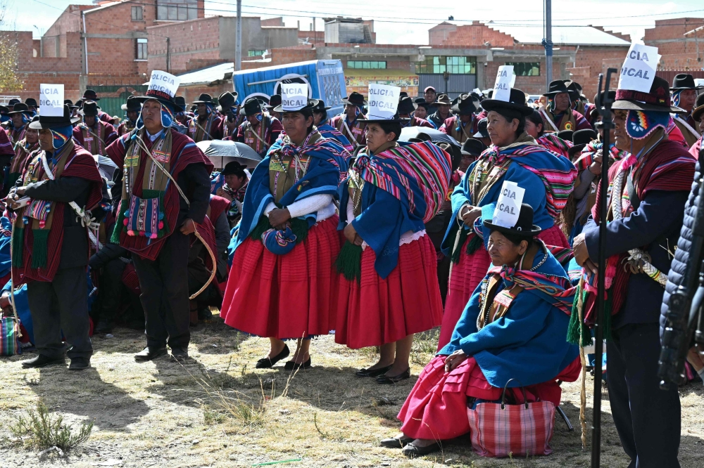 Indigenous people wearing signs reading 
