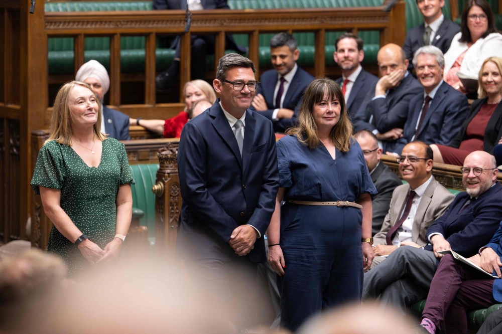A handout photograph released by the UK Parliament shows new Labour Party MP for Makerfield, Andy Burnham (C) arrives to be sworn in after his win in the recent by-election, in the House of Commons in London on May 22, 2026. (Photo by UK Parliament / AFP) 