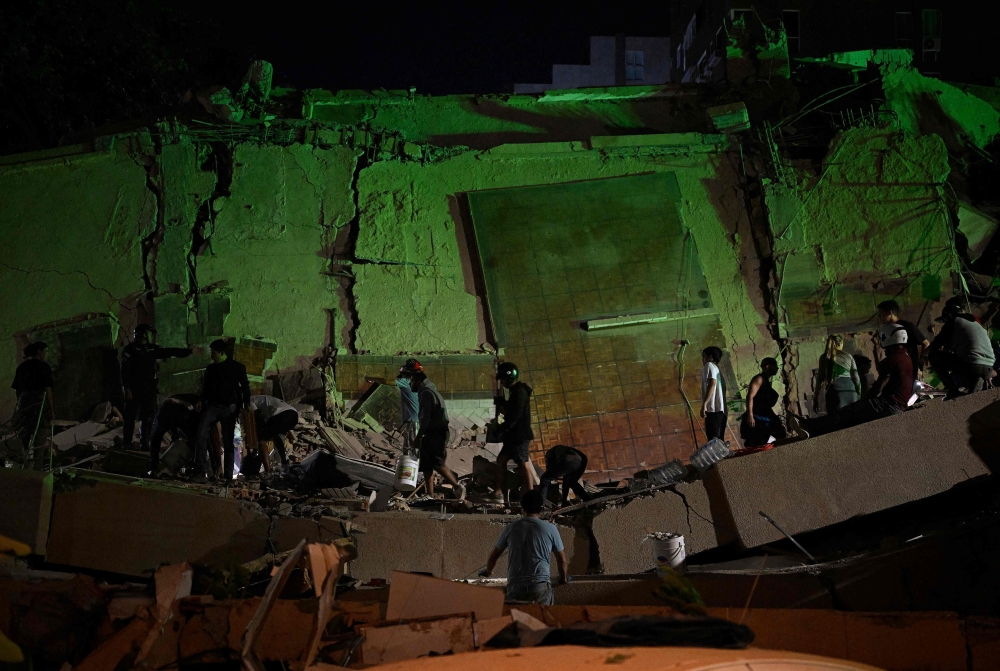 Rescue workers search through the rubble of a collapsed building in the Altamira neighbourhood following an earthquake in Caracas on June 24, 2026. (Photo by Federico ParraARRA / AFP)