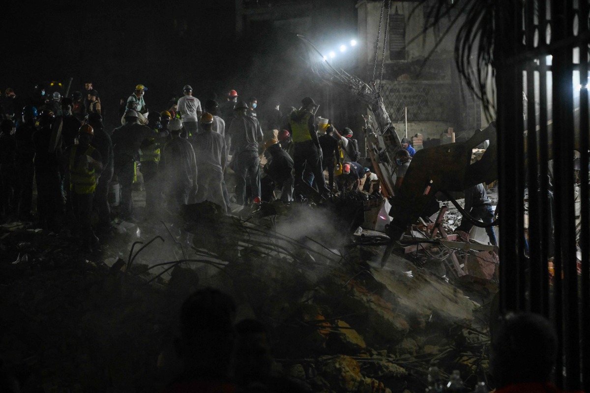 Rescue workers and volunteers search through the rubble of a collapsed building in Caracas on June 25, 2026, following a series of earthquakes. Photo by Maryorin Mendez / AFP