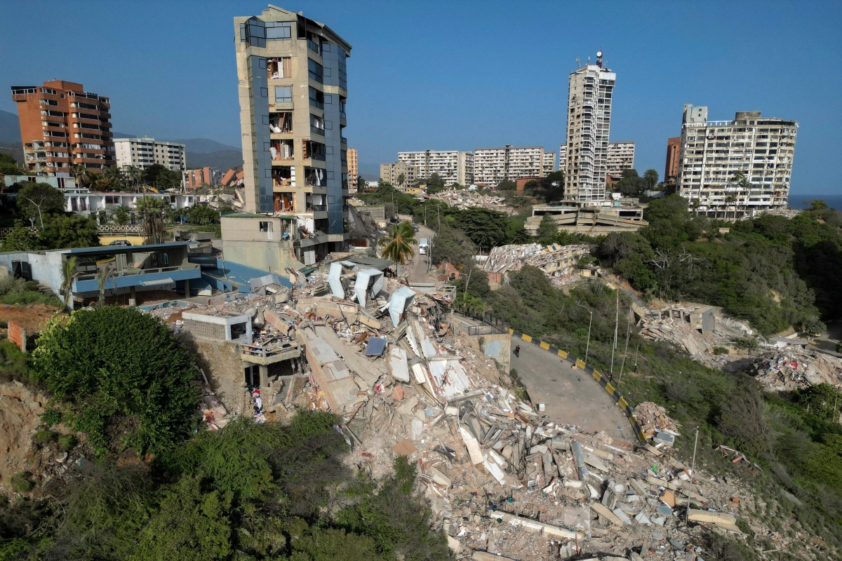 This aerial view shows collapsed buildings in Catia La Mar, La Guaira state, Venezuela, on June 27, 2026, following earthquakes that struck the region. Nearly 1,000 people have been killed and more than 50,000 remain missing after two consecutive earthquakes in Venezuela, where growing anger has been reported over the lack of official aid to swiftly rescue survivors. (Photo by Federico PARRA / AFP)