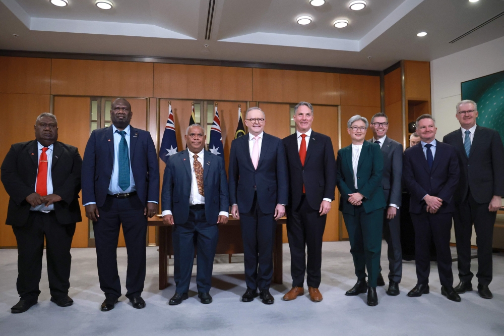 Vanuatu's Trade and Commerce Minister Samson Samsen, Foreign Minister Marc Ati, and Prime Minister Jotham Napat pose for a group photo after an agreement signing ceremony with Australian Prime Minister Anthony Albanese, Defence Minister Richard Marles, Foreign Minister Penny Wong, Minister for Defence Industry and Pacific Island Affairs Pat Conroy, Minister for Climate Change and Energy Chris Bowen, and Minister for Immigration and Citizenship Tony Burke at Parliament House in Canberra on June 29, 2026. (Photo by DAVID GRAY / AFP)